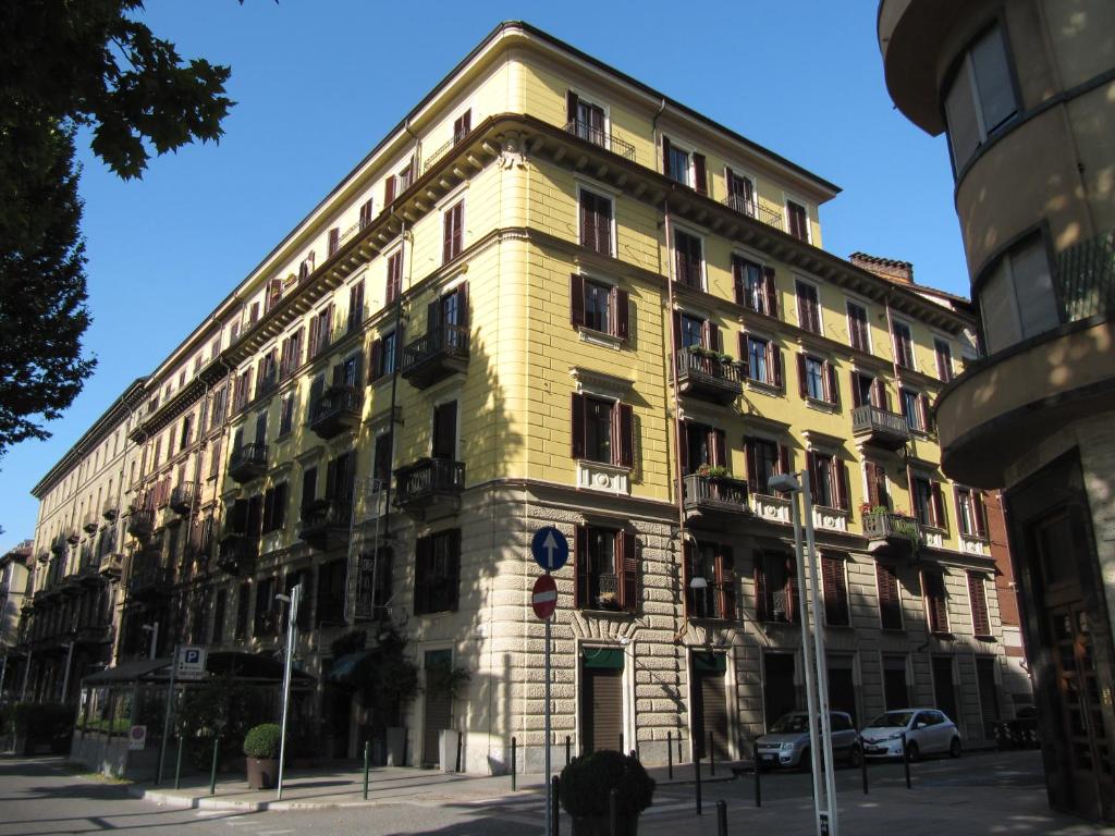 ein gelbes Gebäude an der Ecke einer Straße in der Unterkunft Al Porta Susa B&B in Turin