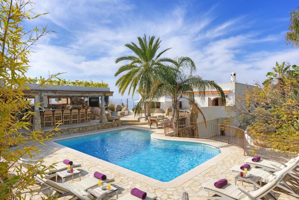 a swimming pool with chairs and a house at Buccara Villa Mistral in Villajoyosa