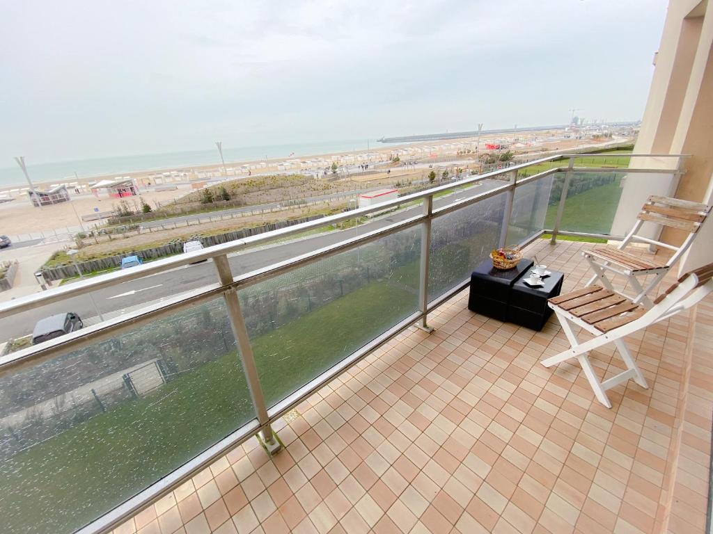 d'un balcon avec une chaise et une table offrant une vue sur l'océan. dans l'établissement The Beach, à Calais
