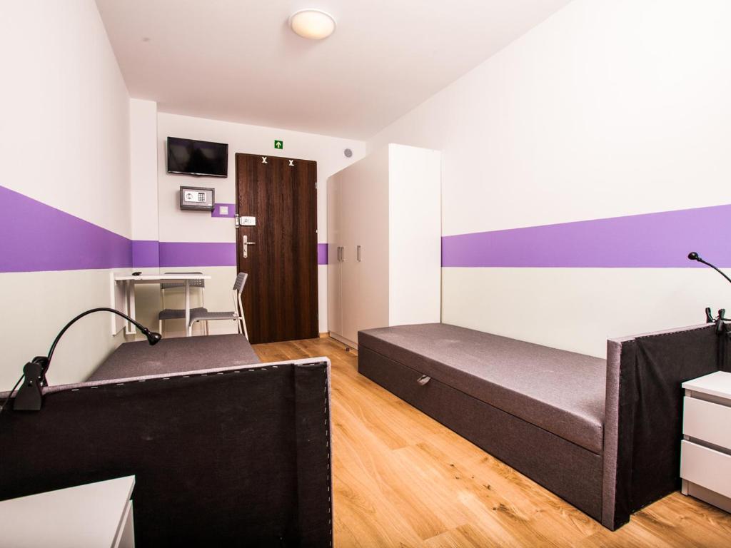 a bedroom with two beds and a desk at SUDO rooms in Wrocław