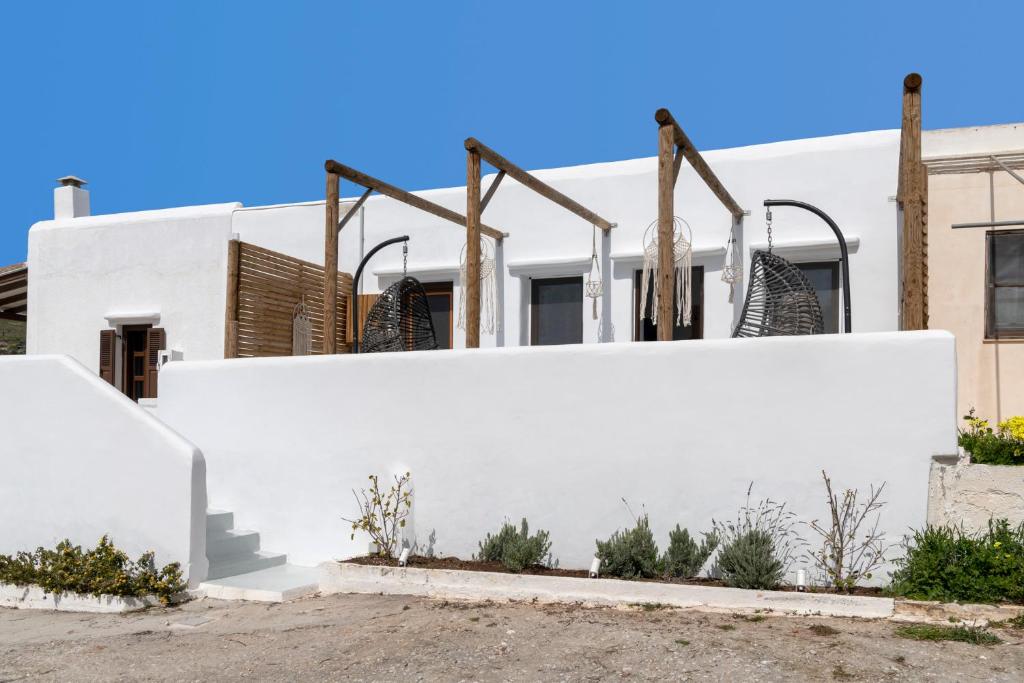 a white wall in front of a building at Endless Blue from Syros - Vari Resort in Vári