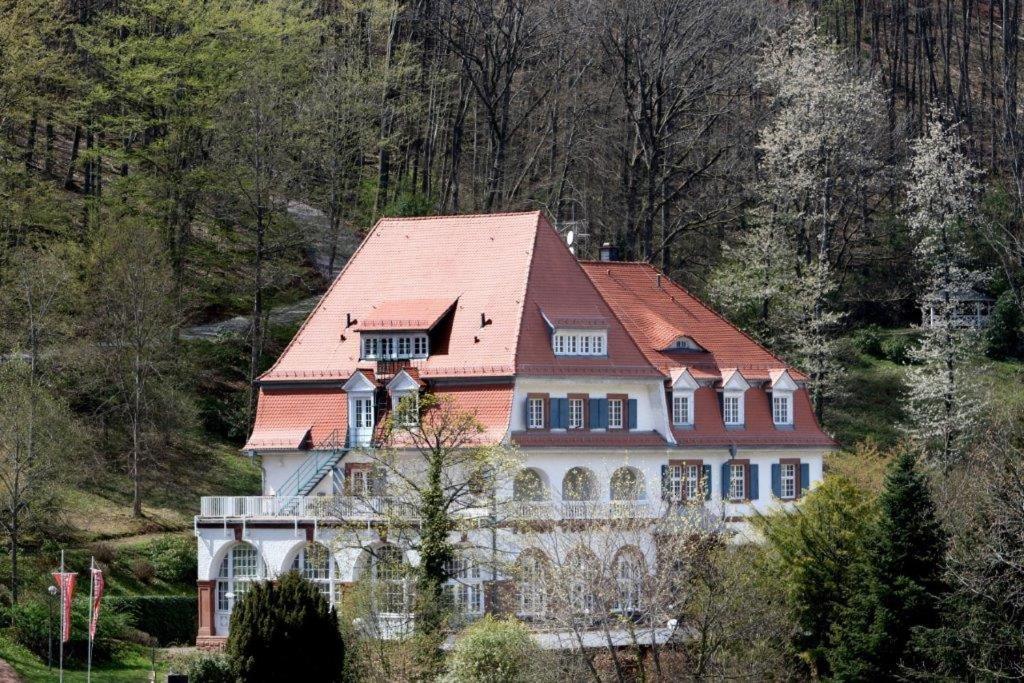 una casa grande con techo rojo en una colina en Jugendstilhotel Trifels, en Annweiler am Trifels