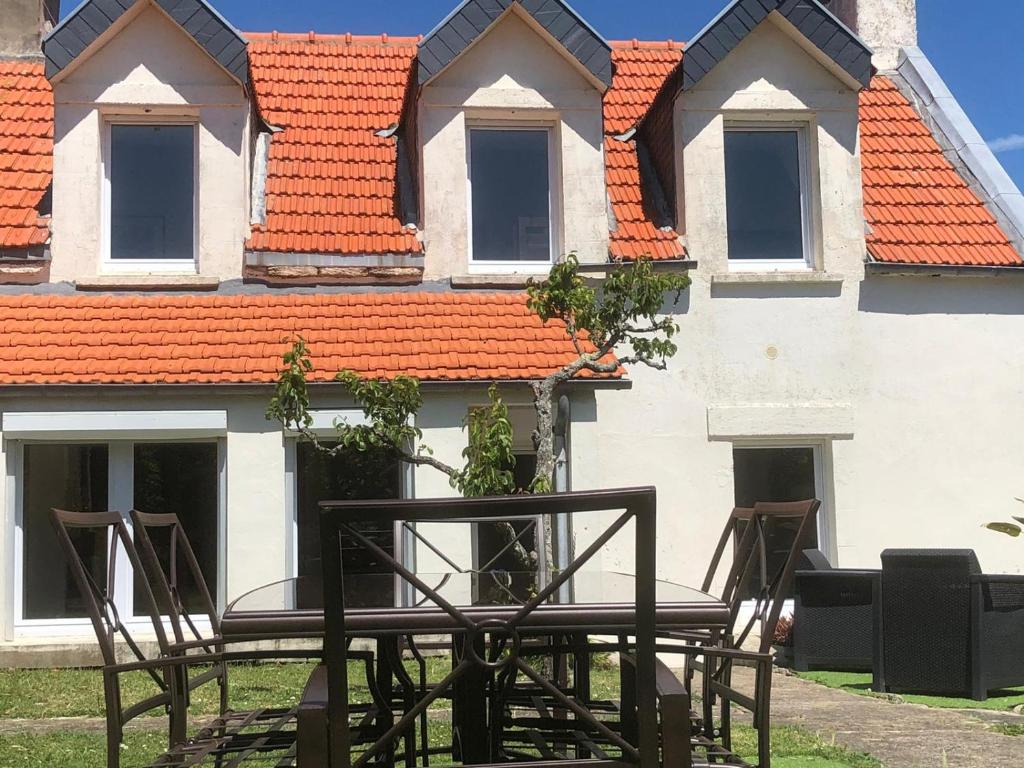 two chairs and a table in front of a building at Maison les figuiers Roch Priol in Quiberon