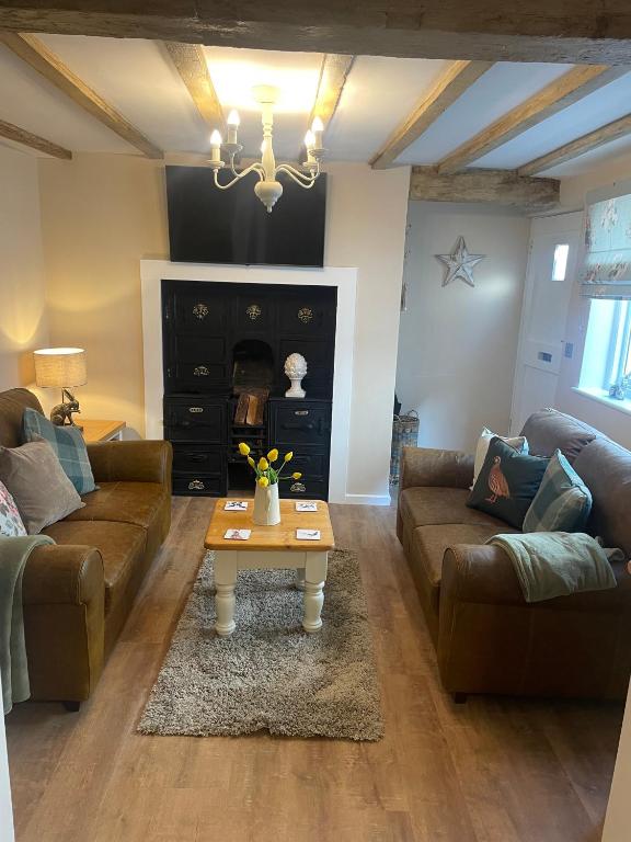 a living room with two couches and a coffee table at Beautiful Bell Cottage Heart of Bridgnorth Walk Everywhere in Bridgnorth
