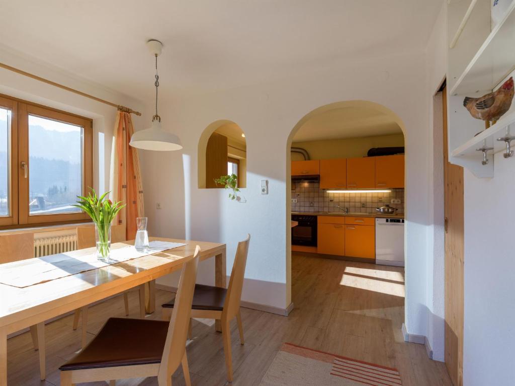 een keuken en eetkamer met een houten tafel en stoelen bij Apartment Rabl in Kirchbichl