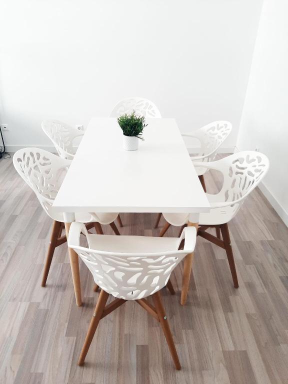 biały stół i krzesła z rośliną w obiekcie DV Properties Residencial Apartment #P4F2 w Maladze