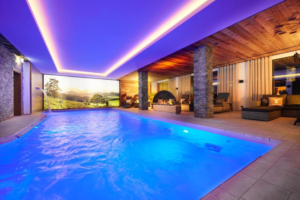 a swimming pool in a house with a fireplace at Landhotel Voss im TalVital in Saalhausen