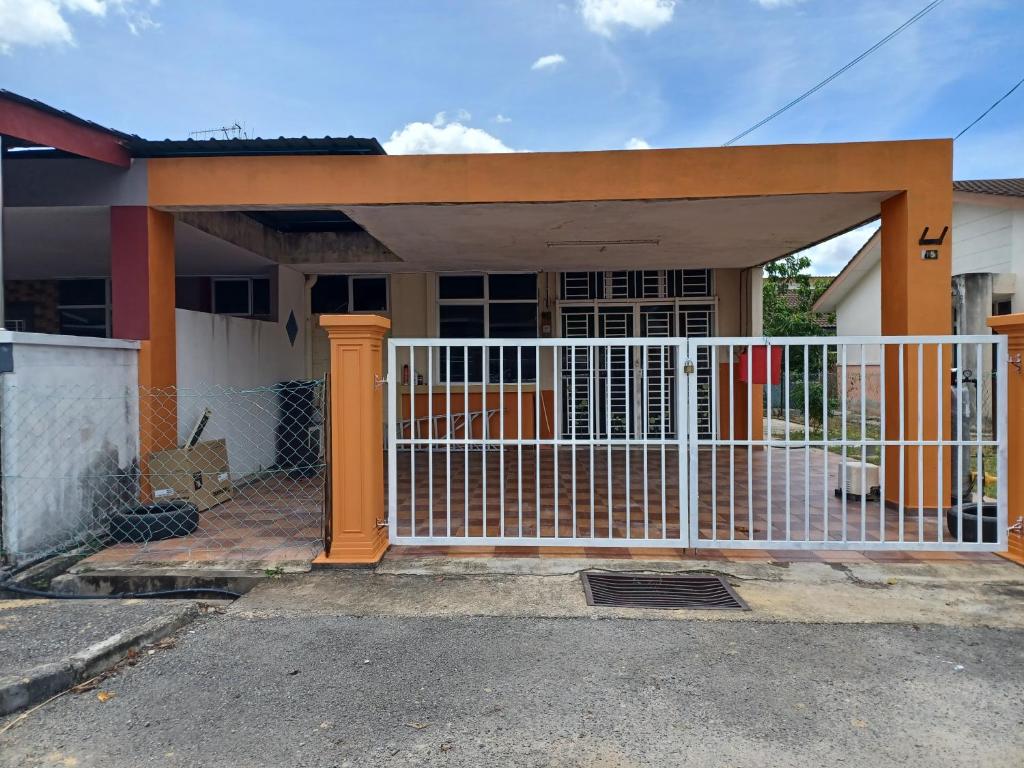 a house with a white gate in front of it at Homestay Dalia, Beseri, Perlis in Kangar