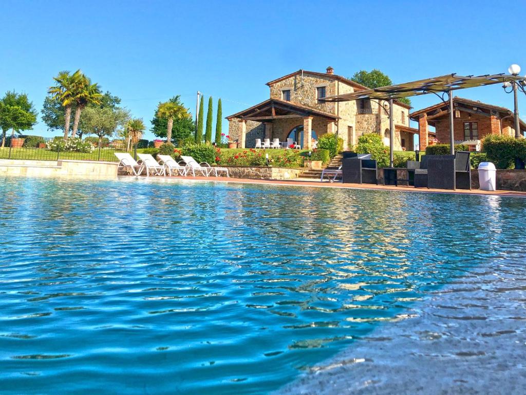 ein Pool mit Stühlen und ein Haus im Hintergrund in der Unterkunft Dimora di Castroncello in Castiglion Fiorentino
