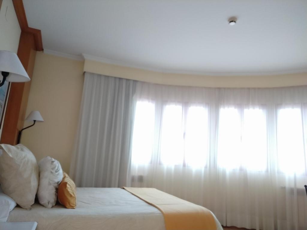 ein Hotelzimmer mit 2 Betten und einem Fenster in der Unterkunft Área de Servicio El Cruce in Manzanares