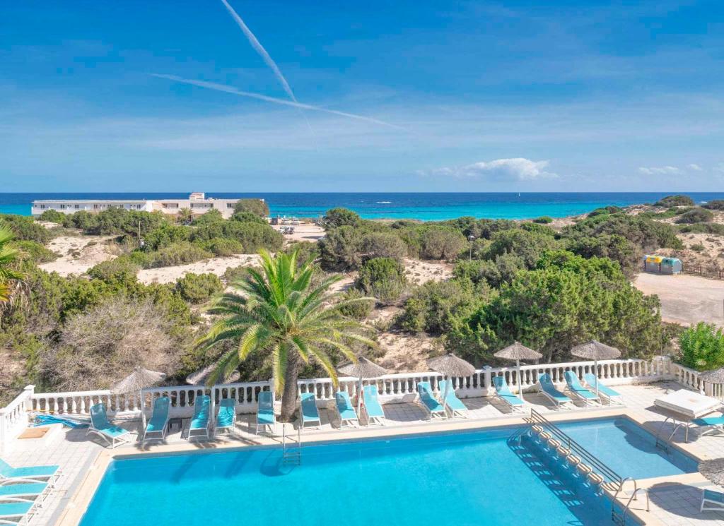 Una vista aérea de un resort con piscina y el océano. en Roquetes Rooms - Formentera Break, en Es Pujols