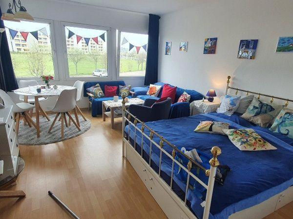 Un dormitorio con una cama, un sofá y una mesa. en Haus-Crone, en Burgtiefe auf Fehmarn 