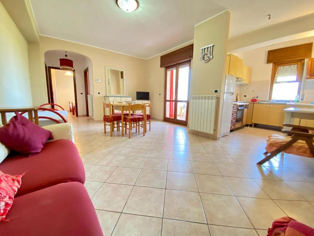 - un salon avec un canapé rouge et une table dans l'établissement B&B Perfetto per famiglia, à Santa Maria del Cedro