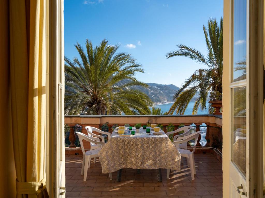 stół i krzesła na balkonie z widokiem na ocean w obiekcie Apartment Belvedere by Interhome w mieście Mortola Inferiore