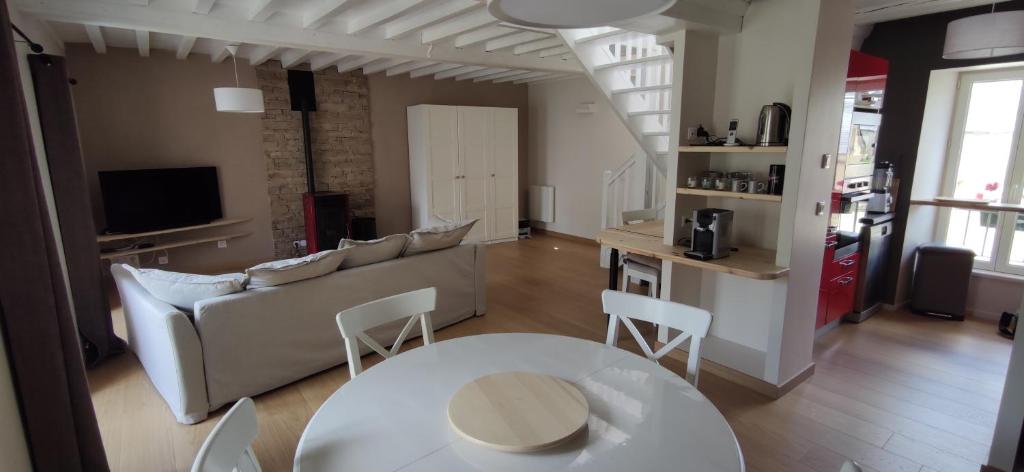 salon z kanapą, stołem i krzesłami w obiekcie Au calme au coeur de Bayeux w mieście Bayeux