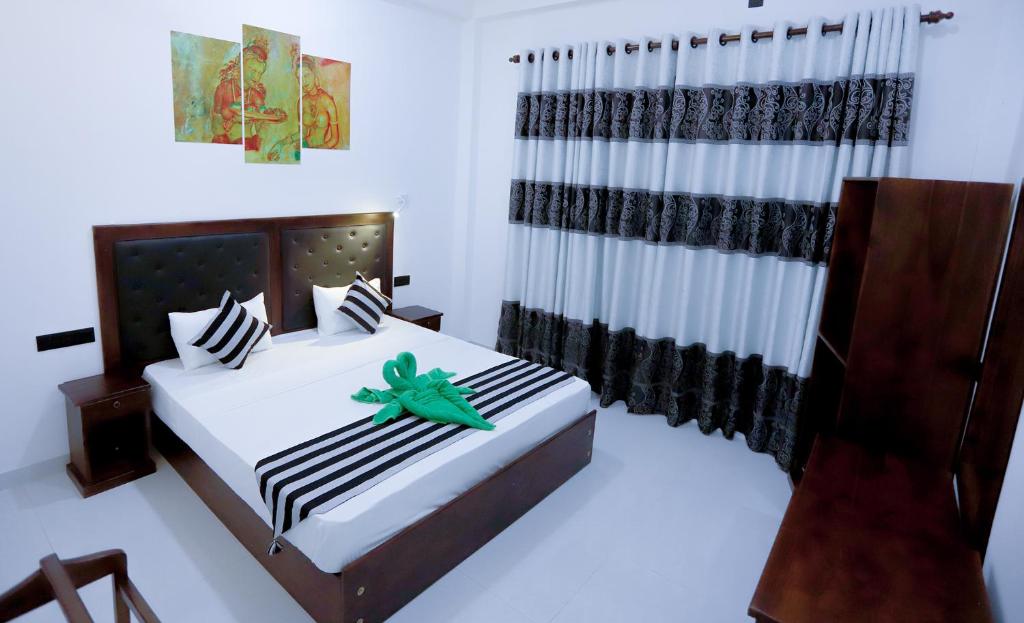 a bedroom with two beds with black and white at Milano Grand in Dambulla