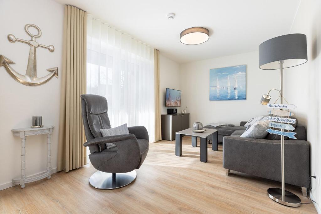 a living room with a chair and a couch at Hansehaus, Moin Moin in Grömitz