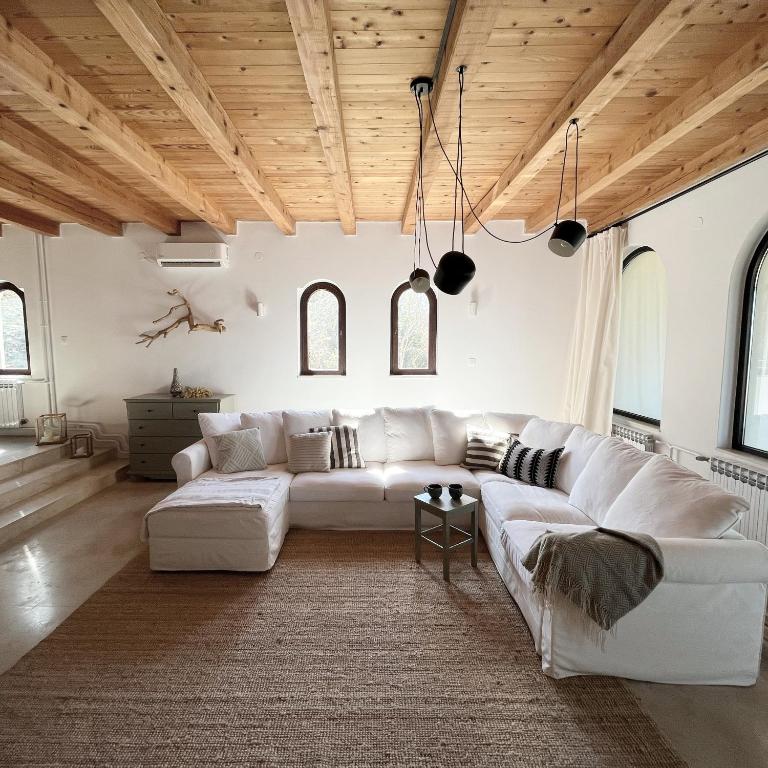 a living room with white furniture and wooden ceilings at Island House Osljak in Preko
