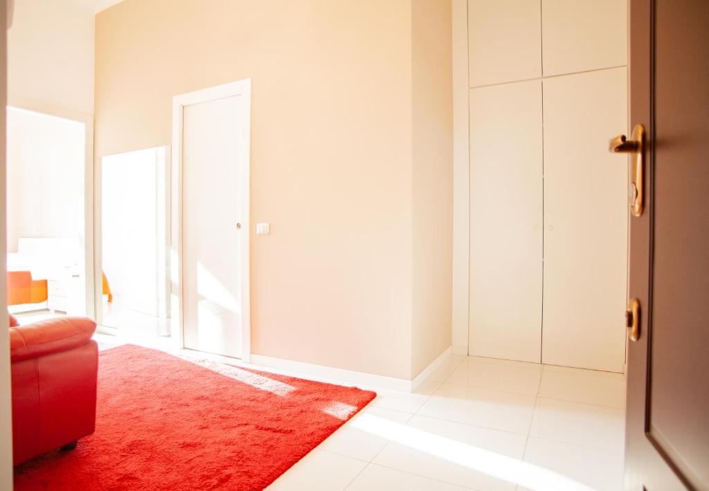 een woonkamer met een rood tapijt en een rode bank bij Lambrate Elegant Bright Apartment in Milaan