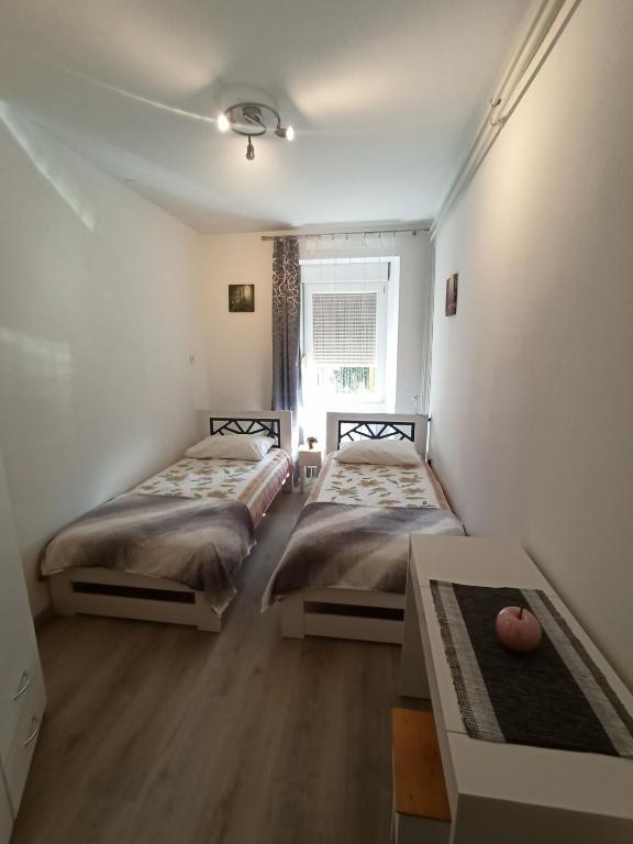 two beds in a room with a window at Apartment Nevela in Bovec