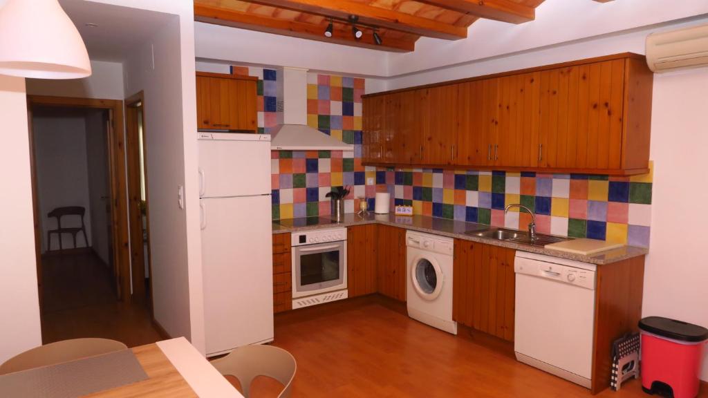 - une cuisine avec des placards en bois et du carrelage coloré au mur dans l'établissement APARTAMENT VALL D´EBO, à Vall de Ebo