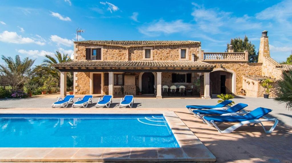 a villa with a swimming pool in front of a house at Finca Es Revolt de Sa Barrala in Campos