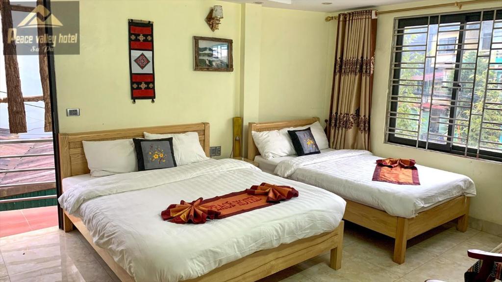 薩帕的住宿－SaPa Peace Valley hotel，一间卧室配有两张带弓的床铺