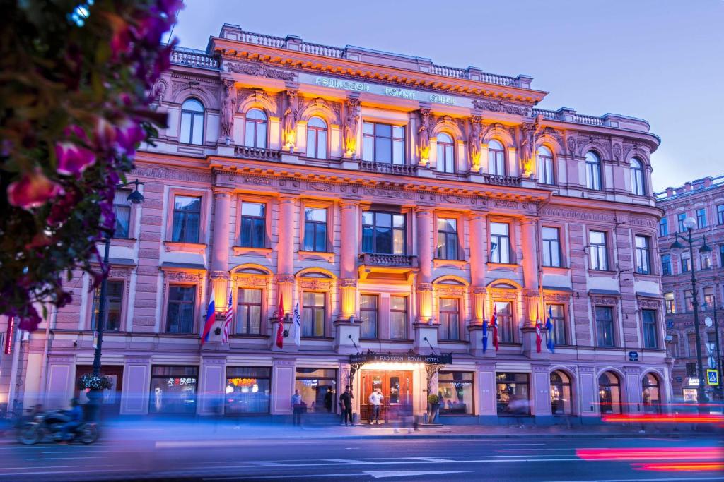 un bâtiment éclairé dans une rue de la ville la nuit dans l'établissement Radisson Royal Hotel, à Saint-Pétersbourg