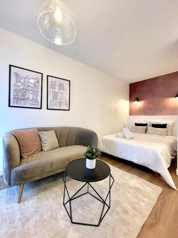 una sala de estar con un sofá y una cama en L'Arizona, en Saint-Étienne