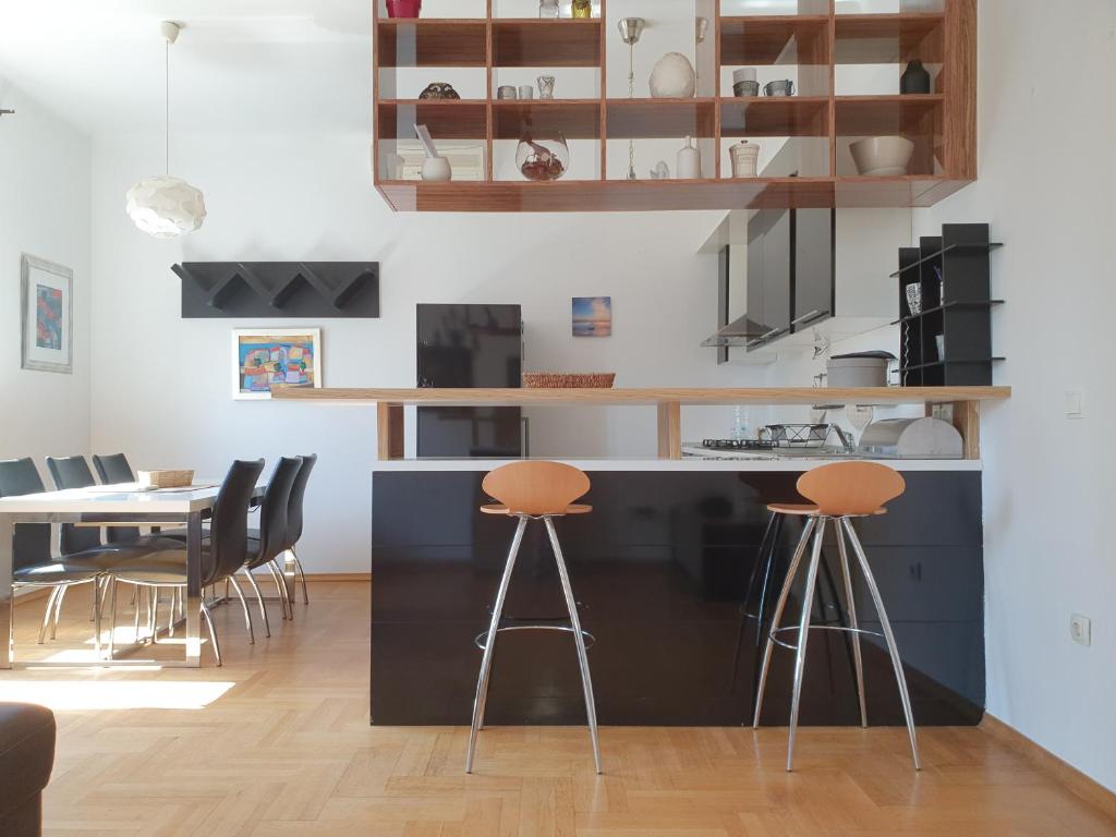 a kitchen with a black counter and stools at Downtown Oasis Zagreb in Zagreb