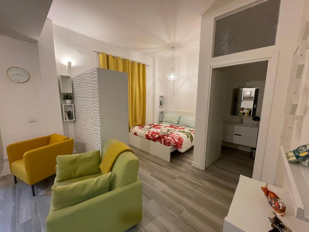 a living room with a bed and a yellow chair at AfforiCentro in Milan