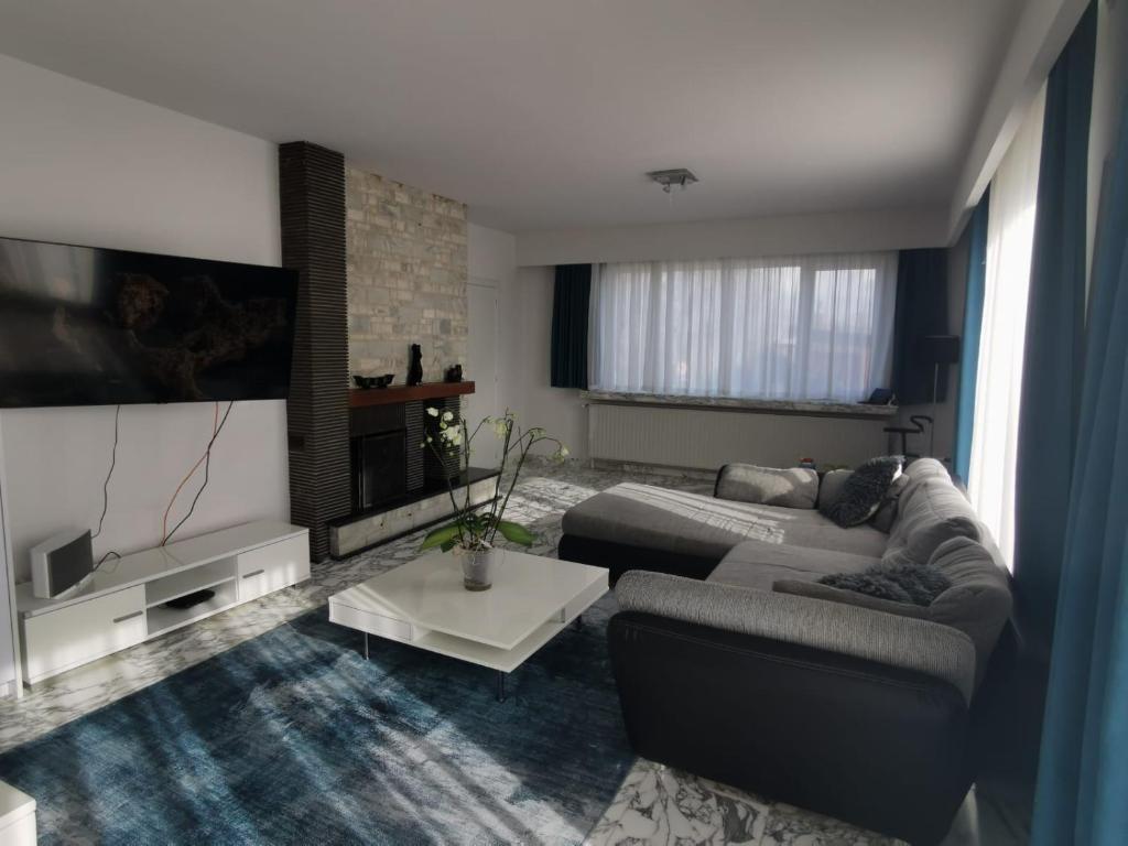 a living room with a couch and a flat screen tv at Spacious villa near a lake in Bredene