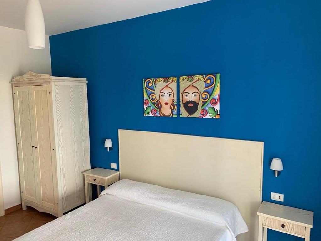 a blue bedroom with a bed and a blue wall at Villa Ancora B&B in San Vito lo Capo