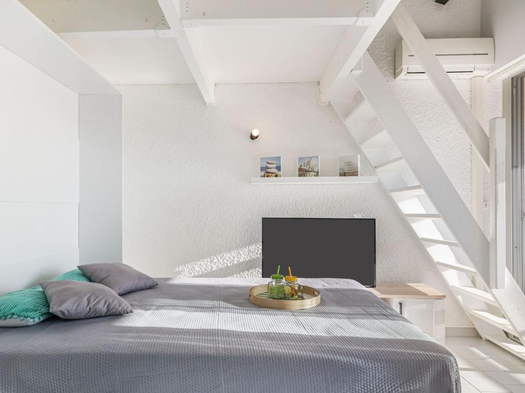 une chambre avec un lit dans une pièce blanche dans l'établissement Apartment Le Florid-11 by Interhome, au Cap d'Agde
