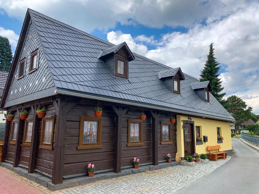 una pequeña casa con techo de gambrel y amarillo en Holiday Home Sissi by Interhome, en Großschönau