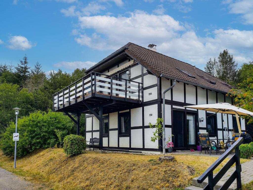 a white and black house with a balcony at Apartment Am Sternberg 250 by Interhome in Frankenau