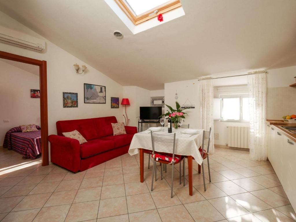 un soggiorno con divano rosso e tavolo di Apartment Stefi by Interhome a Follonica
