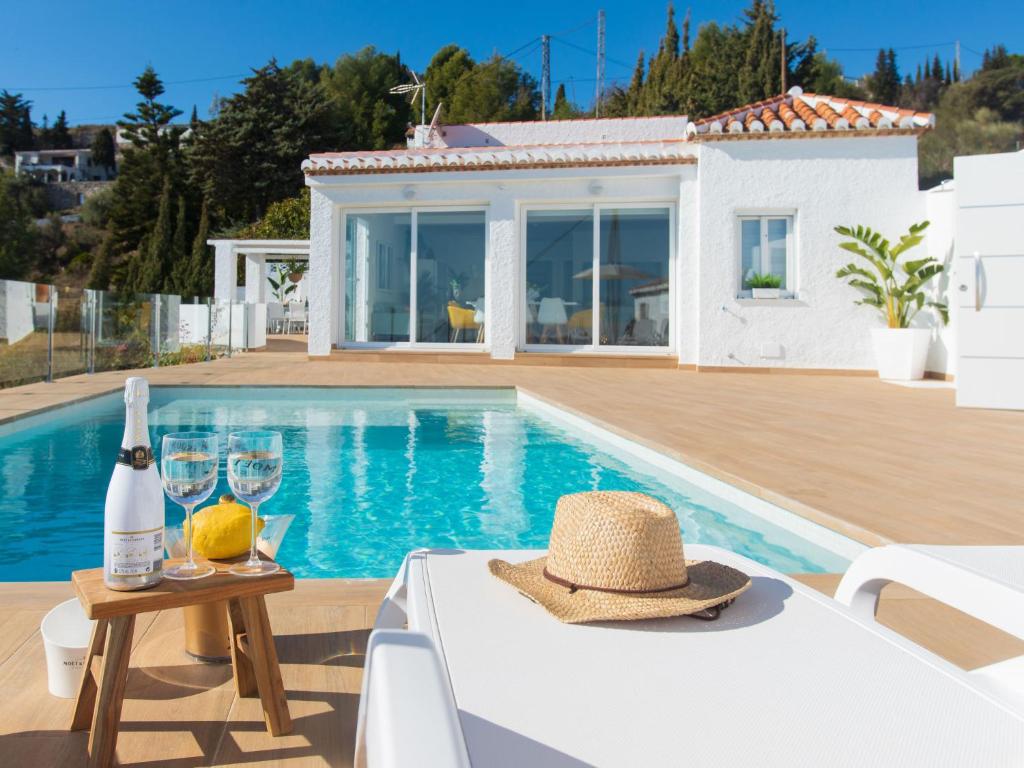 een villa met een zwembad en een tafel met een hoed bij Holiday Home Mediterraneo by Interhome in Almuñécar