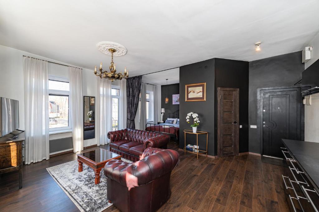 - un salon avec des canapés en cuir et une table dans l'établissement Retro Studio Old Town Apartment by Domvia, à Kaunas
