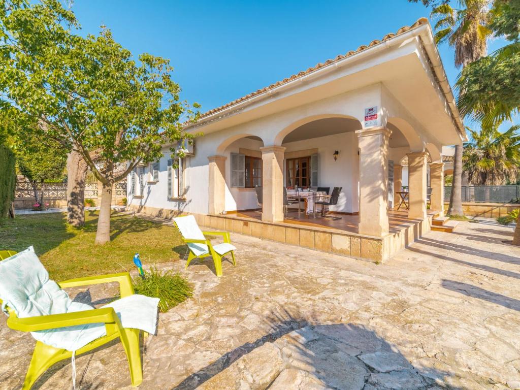 a house with a patio and chairs in the yard at Holiday Home Can Xiroia by Interhome in Alcudia