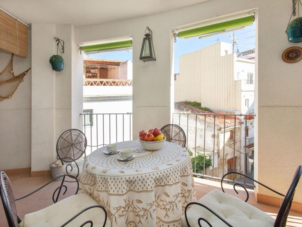 a table with a bowl of fruit on a balcony at Apartment Mitsu by Interhome in Tossa de Mar