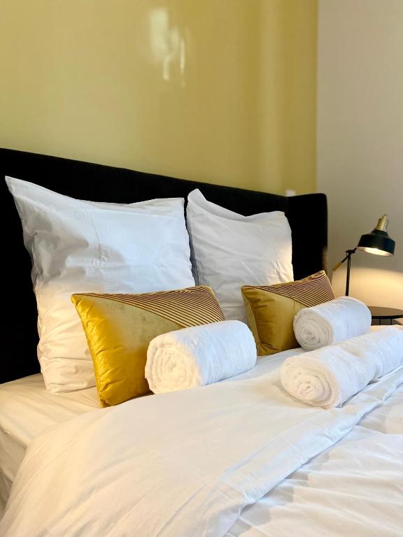 - un lit blanc avec des oreillers jaunes et blancs dans l'établissement La note dorée, à Vichy