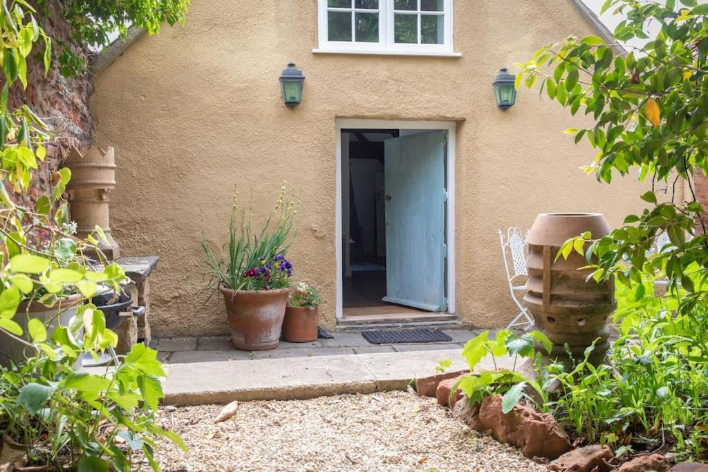 uma porta para uma casa com vasos de plantas em frente em Loft Apartment nr Bath & Bristol with hot tub em Bristol