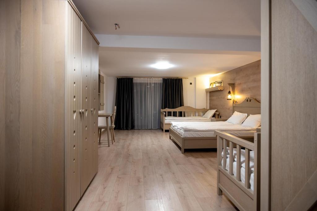a hotel room with two beds and a crib at Pension Mama Cozonacilor in Bran
