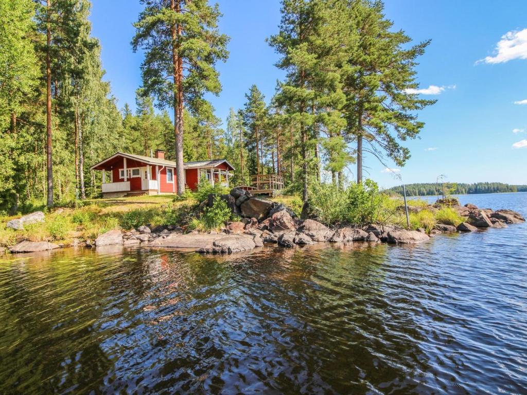 una casa a orillas de un lago con árboles en Holiday Home Niemeke by Interhome en Kotalahti