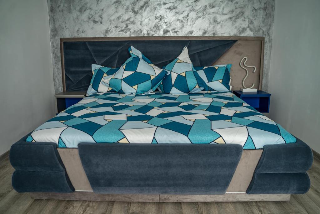 Un dormitorio con una cama azul y blanca con almohadas azules en Studio Lupul, en Petrila