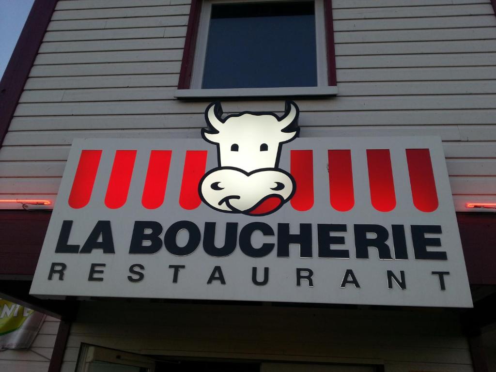 a sign for a la boulevardre restaurant with a cow on it at Contact Hôtel Fontenay le Comte in Fontenay-le-Comte