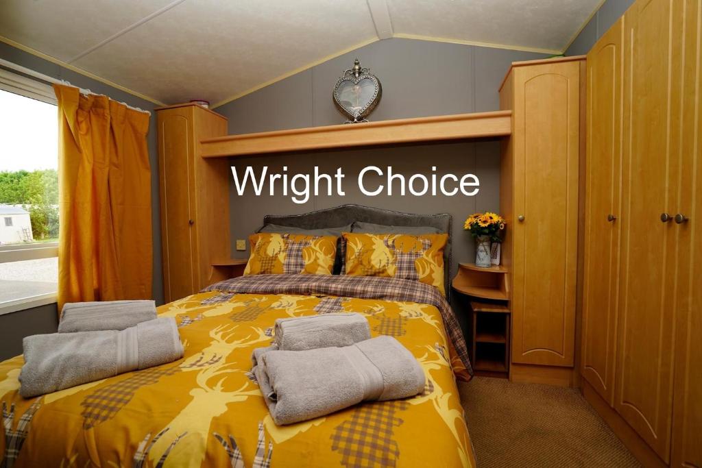a bedroom with a yellow bed with towels on it at Wright Choice caravan rental 5 Lunan View St Cyrus Caravan Park in Saint Cyrus