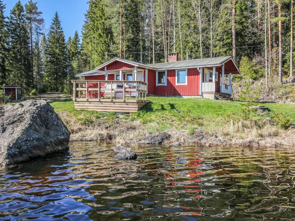 a red house on the shore of a body of water at Holiday Home Lahdeke by Interhome in Kotalahti