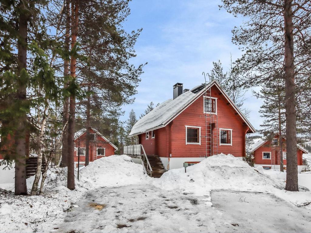 ein rotes Haus im Schnee neben Bäumen in der Unterkunft Holiday Home Alppikylä 4a paritalo by Interhome in Hyrynsalmi